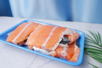 Raw, fresh salmon steak on a plastic packet on table 