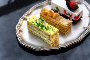 Set of tasty elegant desserts served on silver platter
