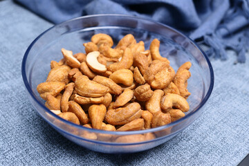 cashew nuts in a bowl on gray background 