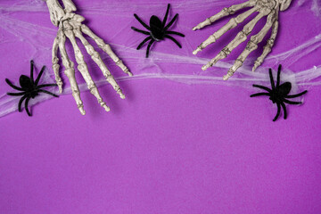 Halloween card with skeleton hands and spiders, purple background. Happy halloween banner mockup