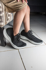 little boy's feet wearing oversized black shoes