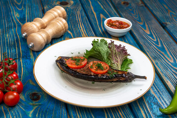 Homemade baked eggplant served with cherry tomatoes, pepper and chili sauce