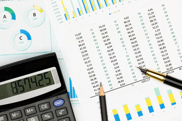 Top view office table desk. Financial report. Flat lay. Workspace with Business office supplies, Accounts number on the data paper, pencil, pen, glasses, calculator on the table. Top view. Close-up