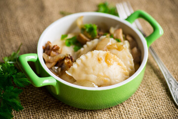 Potato dumplings with onion and mushrooms in a plate.