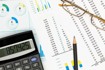 Top view office table desk. Financial report. Flat lay. Workspace with Business office supplies, Accounts number on the data paper, pencil, glasses, calculator on the table. Top view. Close-up