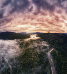 sunset in the taiga on a mountain river. Fog in the forest at sunset, view from a drone.