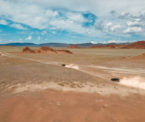 Two cars off-road in the desert. a lot of roads are dusty. drone view