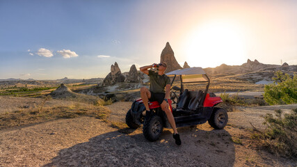 a man on a buggy stopped to drink an energy drink. on the background of a beautiful landscape © Roman