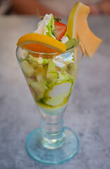 Ein Eisbecher mit den unterschiedlichsten Früchten auf einem Tisch.