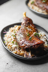 Closeup of duck led served with baked vegetables and parmesan cheese