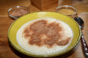 Ein Teller mit Griesbrei, Apfelmus, sowie Zimt und Zucker.
