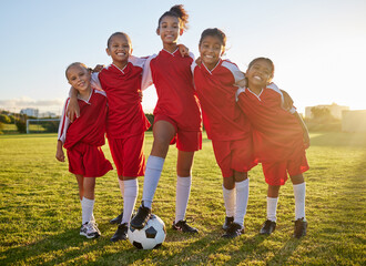 Soccer, team sports and portrait of children training for football game on a grass field together. Happy, smile and young group of girl athletes in partnership and teamwork for sport match at school