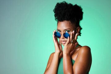 Portrait of trendy black woman in green background with sunglasses. Mockup for natural beauty,...