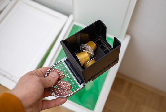 throwing coffee capsules in the trash bin