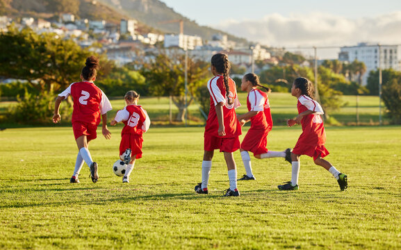 Girl, soccer and fitness team in field sports playing fun game together in training for competition outdoors. Group of female football players in teamwork sport match for health and exercise outside
