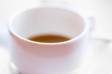 Defocused view of white cup of hot coffee