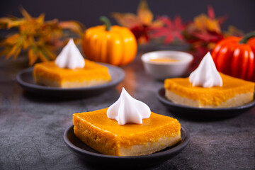 Slice of fresh baked traditional american homemade pumpkin pie decorating whipped cream for celebrating holidays