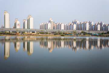 BUCHEON, SOUTH KOREA: line of typical apartment buidings (called Danji in Korean) and reflection in a lake