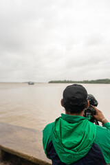 Journalist recording video on the coast of Bluefields Nicaragua with a cloudy sky