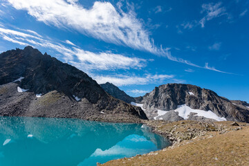 Fototapeta na wymiar View of a blue mountain lake in the Caucasus Russia against the background of impressive steep mountain peaks
