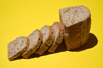 Bread. Sliced  bread's loaf with seeds on a yellow background. Healthy Diet. sliced organic bread. Top view. Artisan bread with seeds. Rustic sourdough bread.