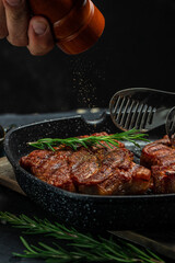 Chef hands cooking meat steak and adding seasoning in a freeze motion. vertical image. place for...