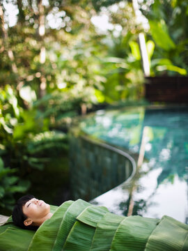 Woman wrapped in banana leaves at a Spa in Ubud, Bali, Indonesia.