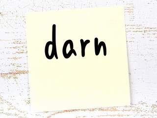 Yellow sticky note on wooden wall with handwritten word darn - obrazy, fototapety, plakaty