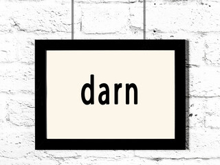 Black frame hanging on white brick wall with inscription darn © iushakovsky