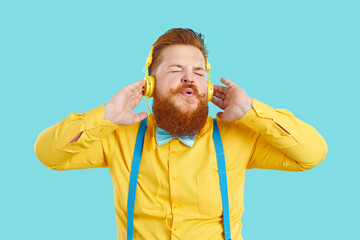 Funny chubby man listening to music. Happy handsome fat guy with ginger beard and handlebar...