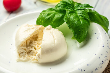 fresh soft white burrata cheese ball made from mozzarella and cream from Apulia, Italian Mediterranean cuisine, Food recipe background. Close up