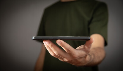 Caucasian man holding smartphone at home.