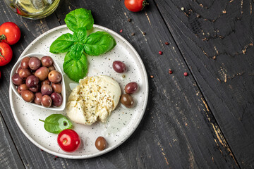 Creamy Italian Burrata Cheese with basil and olive oil on white plate. Italian Mediterranean cuisine. place for text, top view