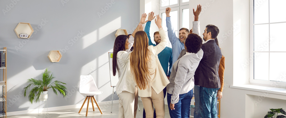 Wall mural happy young peoples stand in circle raise their hands up with smile during team building business ev