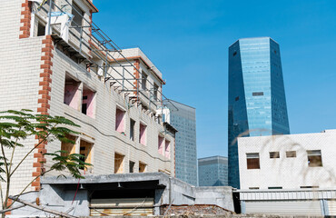 Contrast of old house and modern skyscraper
