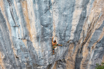 Fototapeta premium Extreme sport, strong man, rock climber climbs a difficult route.