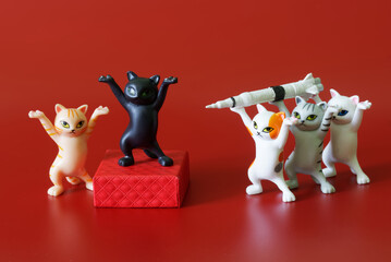 The toy dancing kittens from the meme carry a rocket to their boss. Preparation for the use of weapons of mass destruction. Nuclear blackmail. Apocalyptic anti-war concept. Red background.