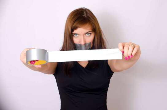 Young woman with taped mouth