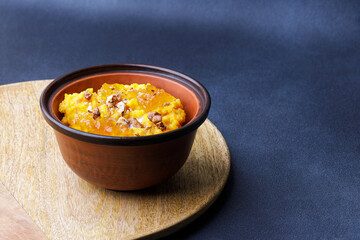 Sweet pumpkin porridge in clay bowl with jam and nuts