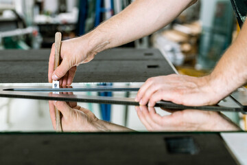 Glazier cuts a mirror on a special table, Glass industry
