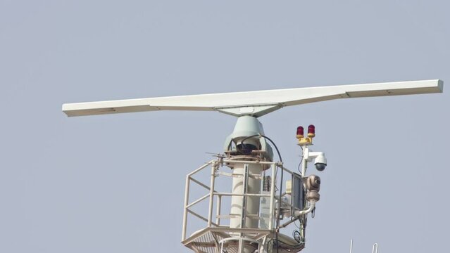 Spinning rotating radar equipment on top of a ship - in front of the sky