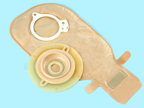 One colostomy bag and colostomy disc on blue background .Bowel cancer