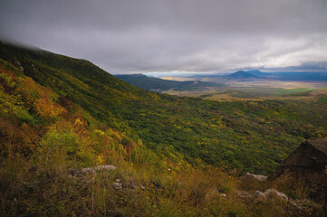 rocky cliff at the foot of the village against a cloudy sky, after or before a thunderstorm, panoramic view