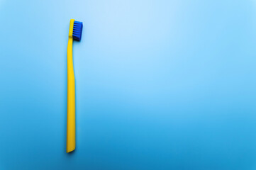 top view close-up of a bright toothbrush, alone, without people, lies on a blue background