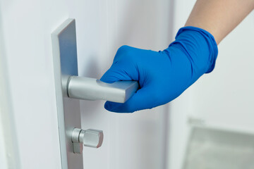 Woman's hand open the door with glove