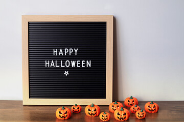 Felt letter board with phrase happy halloween with pumpkin on gray background.halloween day composition.party greeting card.