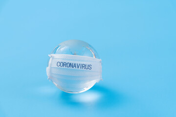 Earth globe with medical mask on blue background