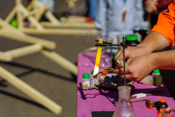 The teacher squeezes a hot test tube with metal tongs