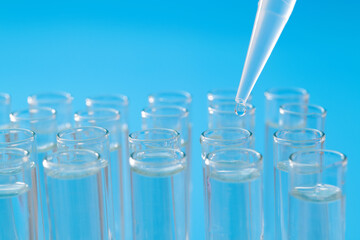 Liquid drop to test tube on blue background