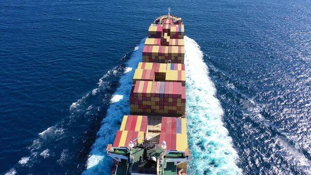 Aerial drone video of MSC truck size container cargo vessel cruising in deep blue sea near commercial port of Piraeus, Attica, Greece